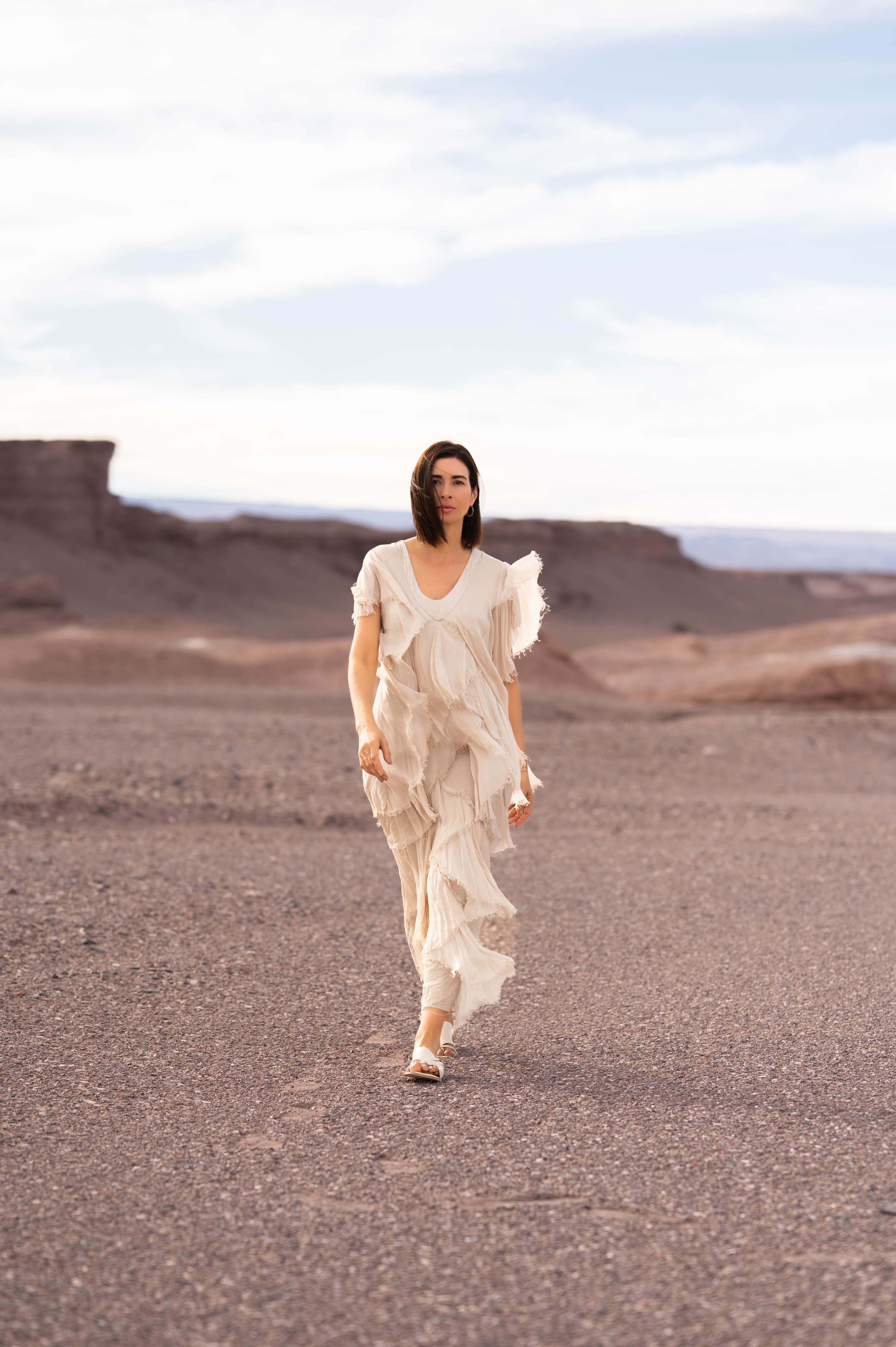 Modelo com o Vestido Ilha de Elba sendo movimentado pelo vento, destacando leveza e elegância.