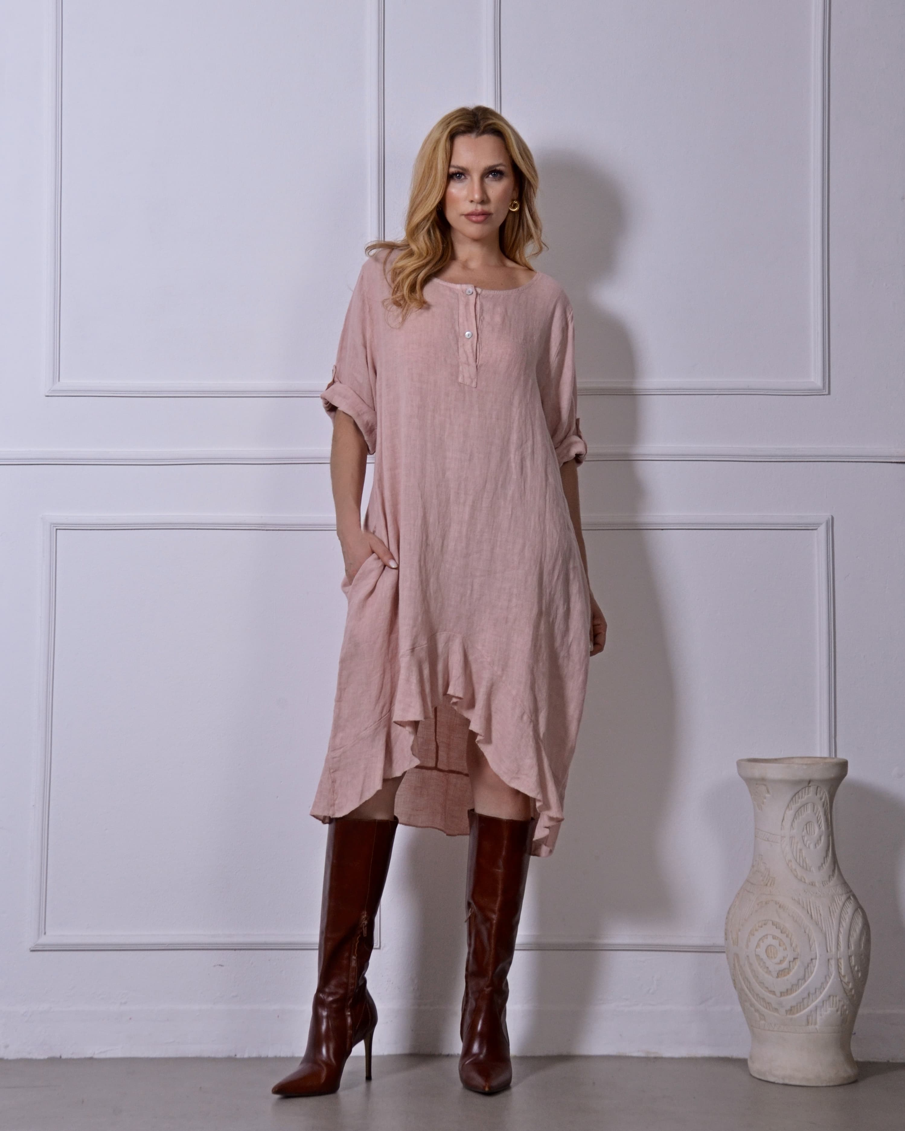 Modelo com vestido rosa em linho e botas marrons, look sofisticado.